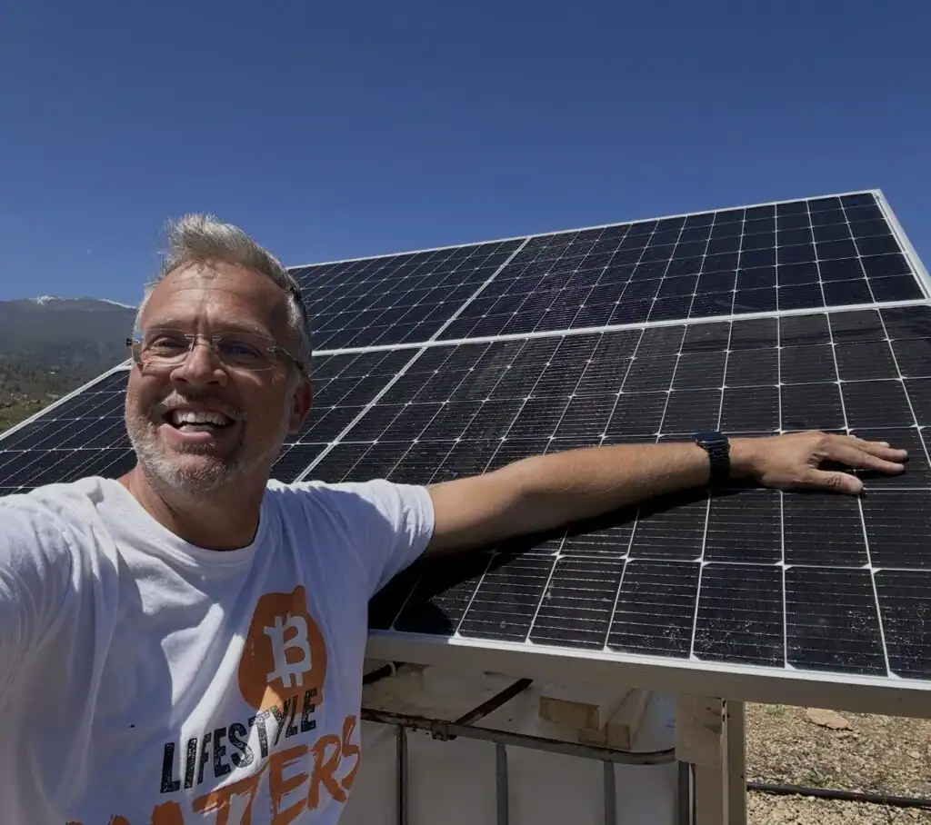 Green Bitcoin Farm founder beside photovoltaic modules